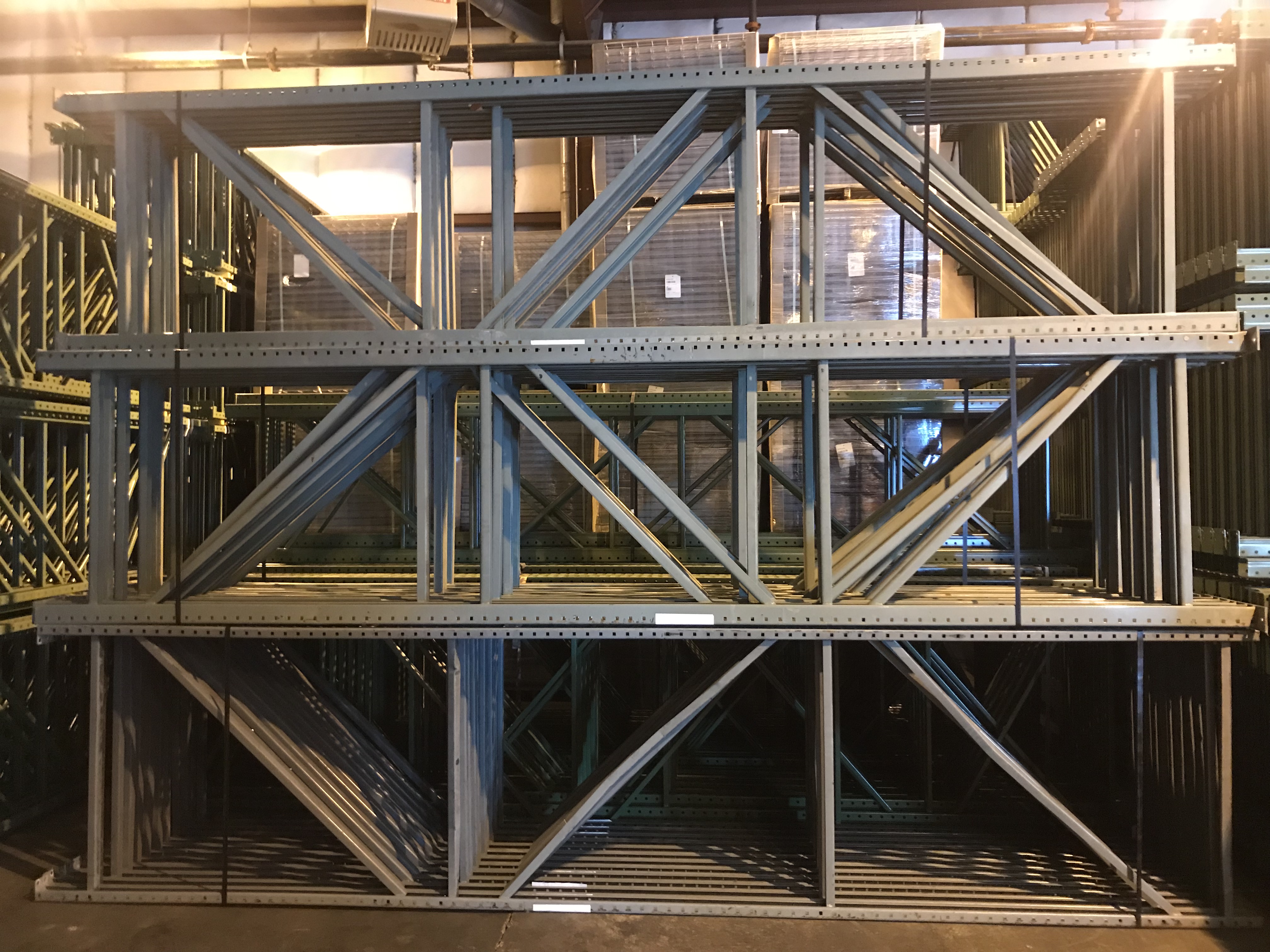 Gray pallet racking dismateled side structures leaned against each other.